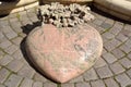 Pink-colored heart-shaped sculpture with German inscriptions